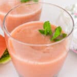 a 45 degree angle view of served watermelon smoothie with mint leaves.