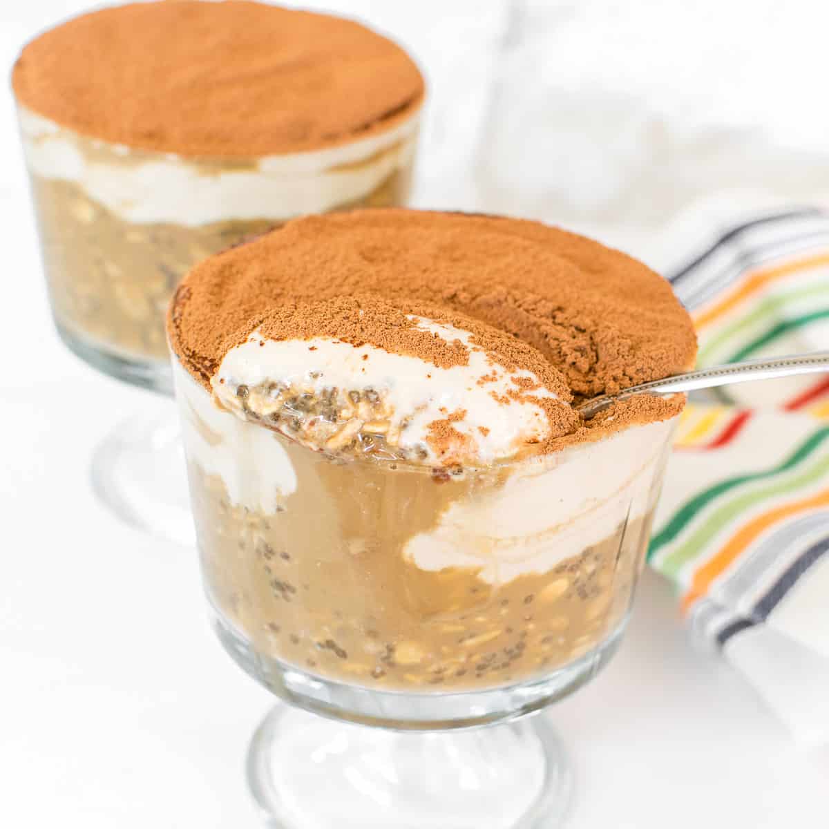 a spoon filled with tiramisu overnight oats from the serving cup. 