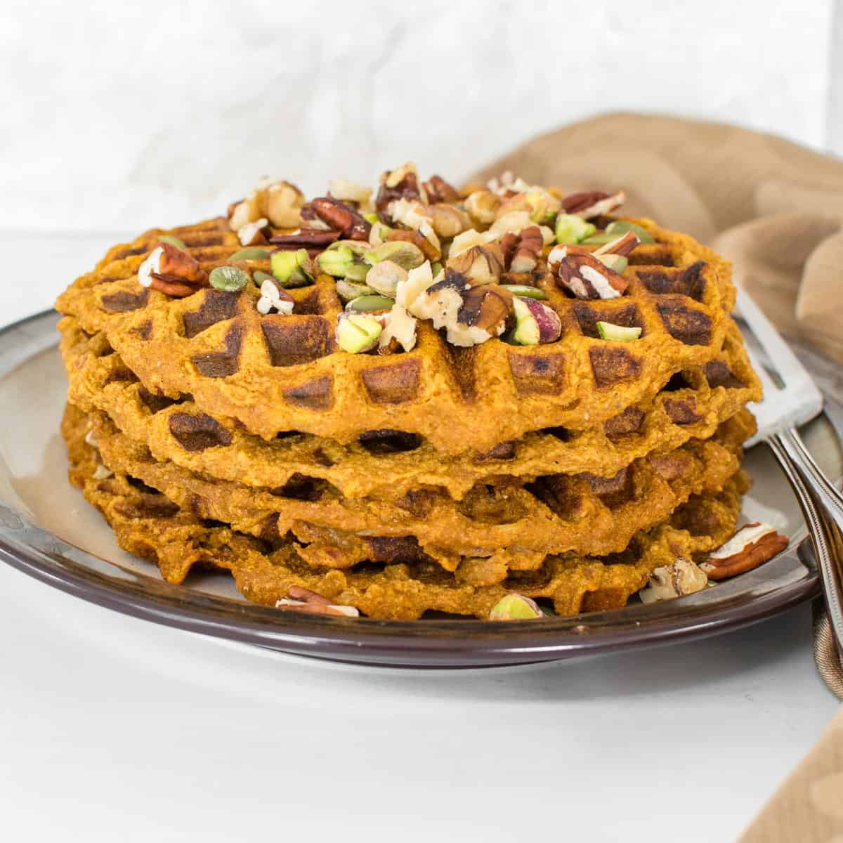 stacked whole pumpkin waffles with its garnishes.