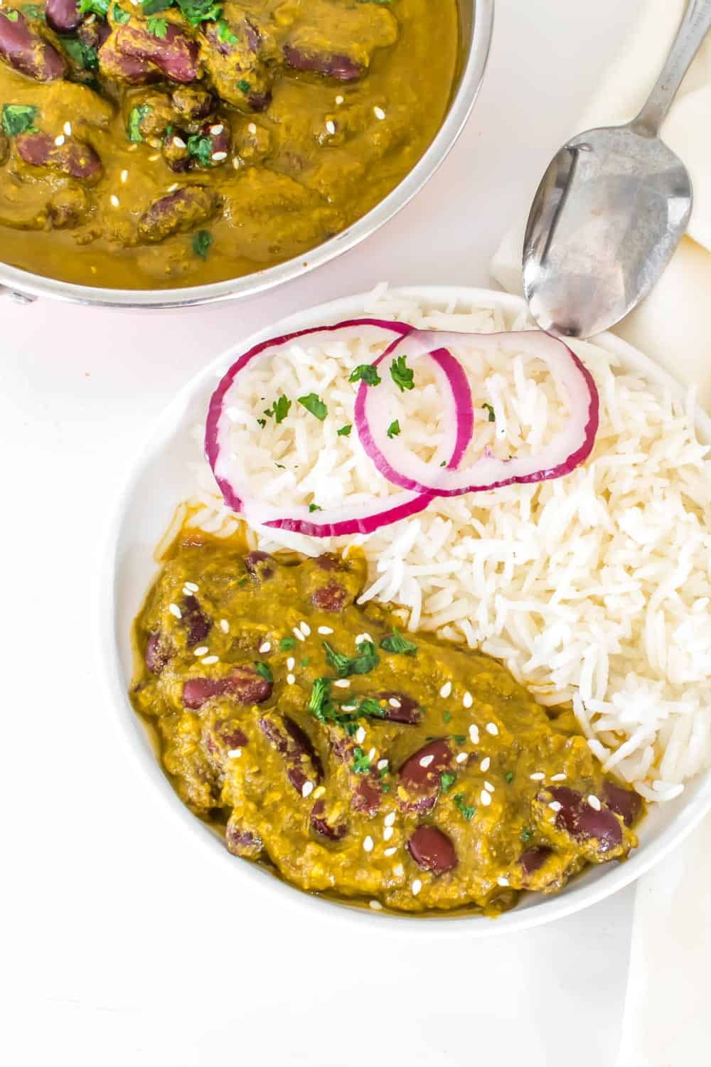 top view of the served rajma masala with rice along with the serving kadhai.
