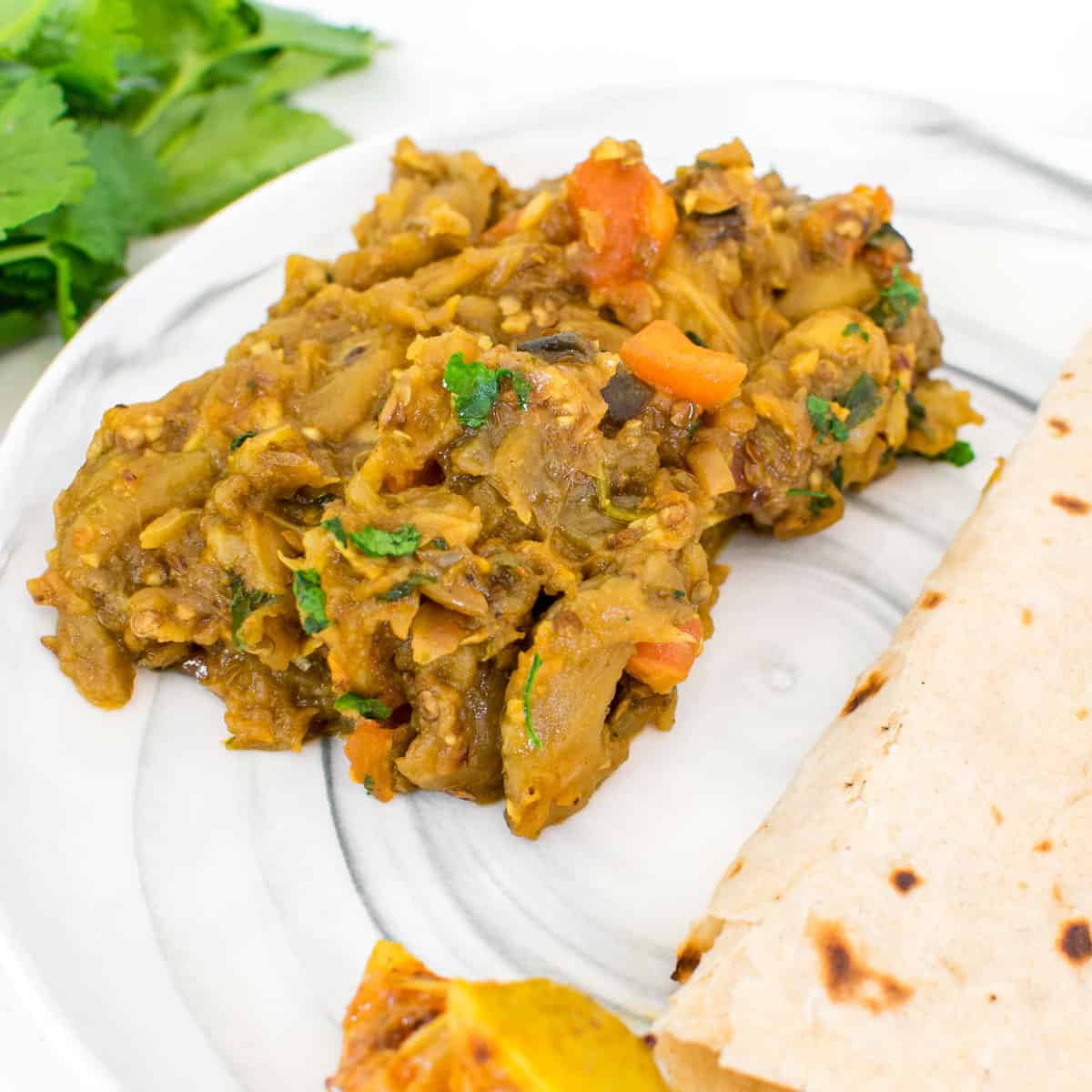 This Easy Baingan Bharta (Indian Mashed Eggplant) brings together the smoky goodness of roasted eggplant with a medley of aromatic spices, resulting in a creamy and satisfying mashed eggplant dish that is sure to tantalize your taste buds | kiipfit.com