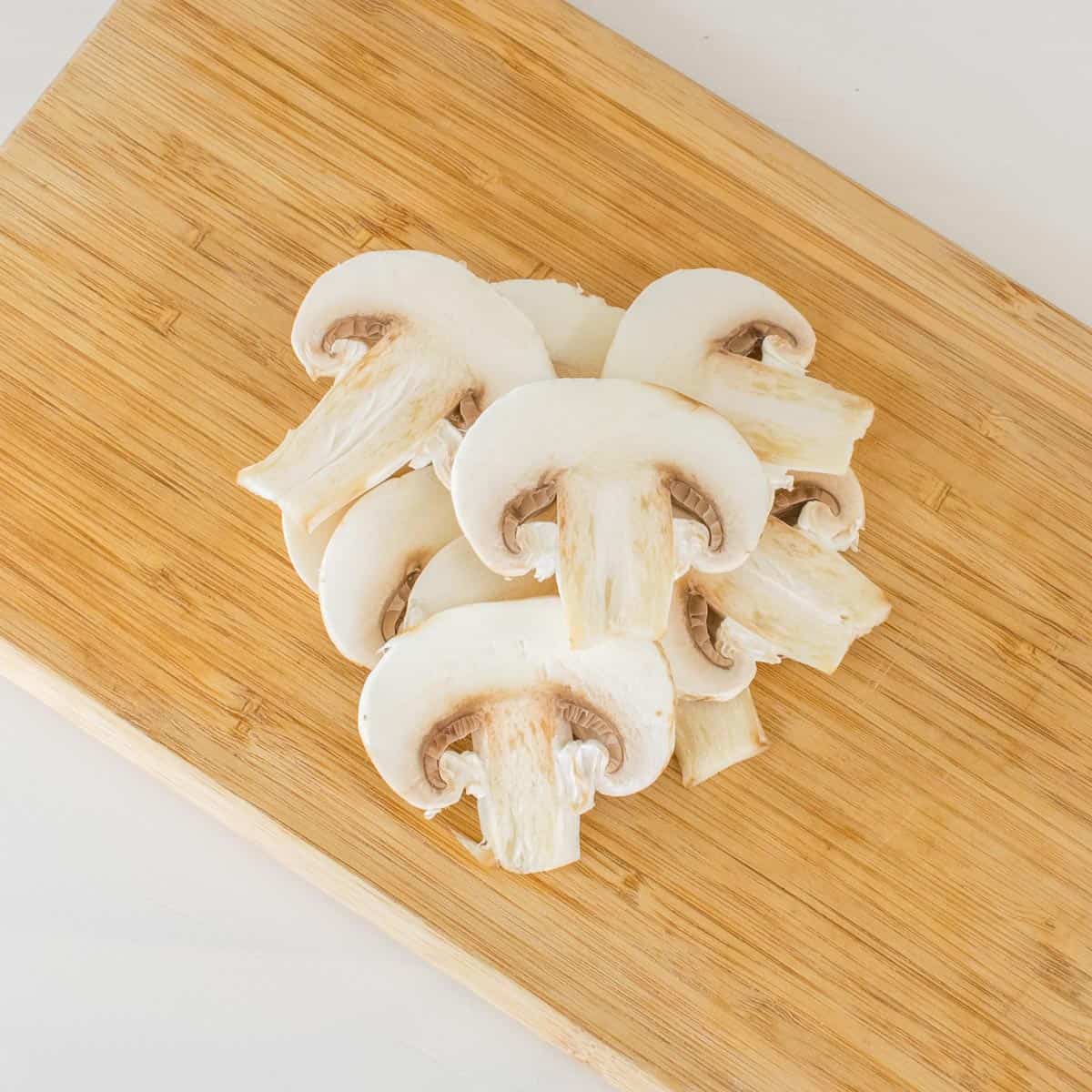 chopped mushrooms on a wooden board.