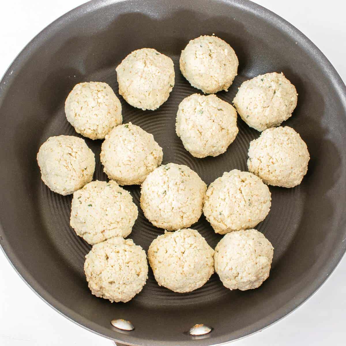 shaped meatballs in a cooking nonstick pan.