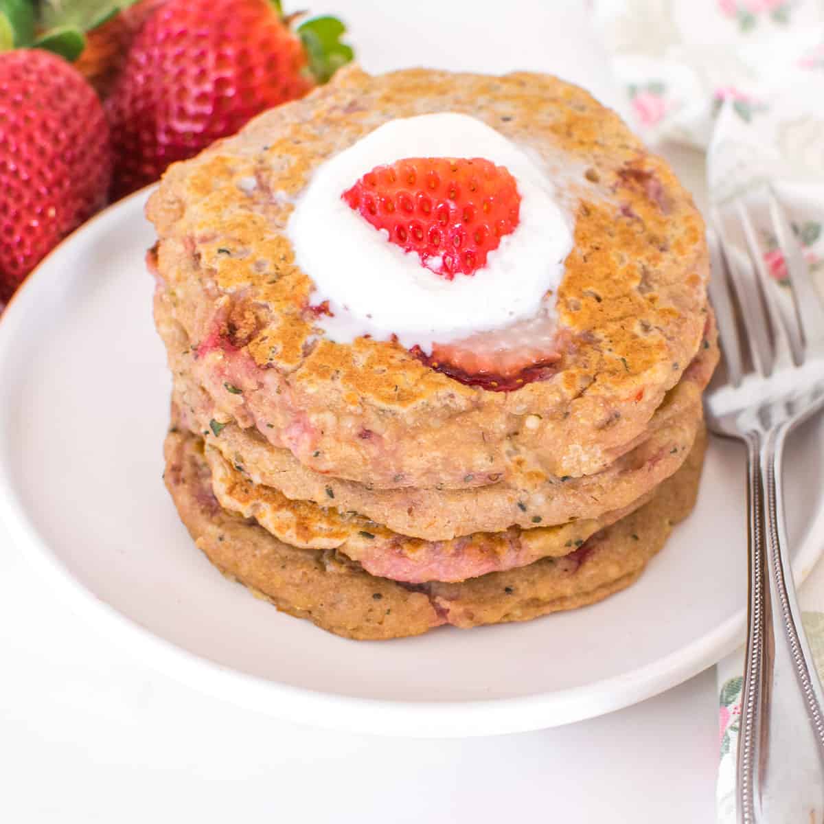 a 45 degree angle view of stacked strawberry pancakes.