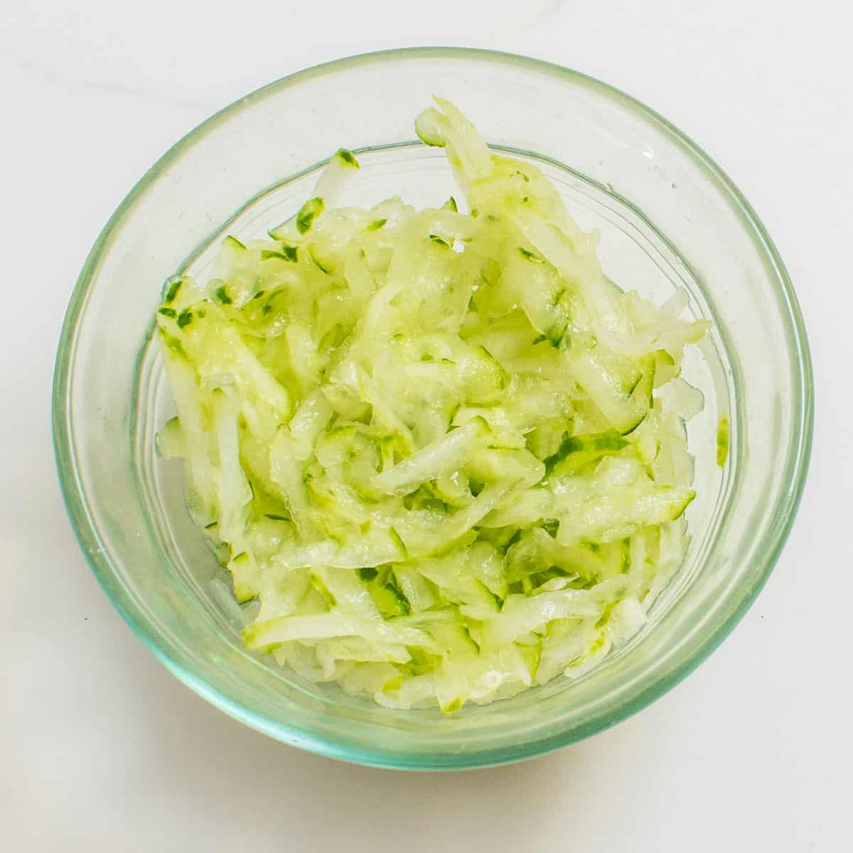 grated cucumber in a small glass bowl.