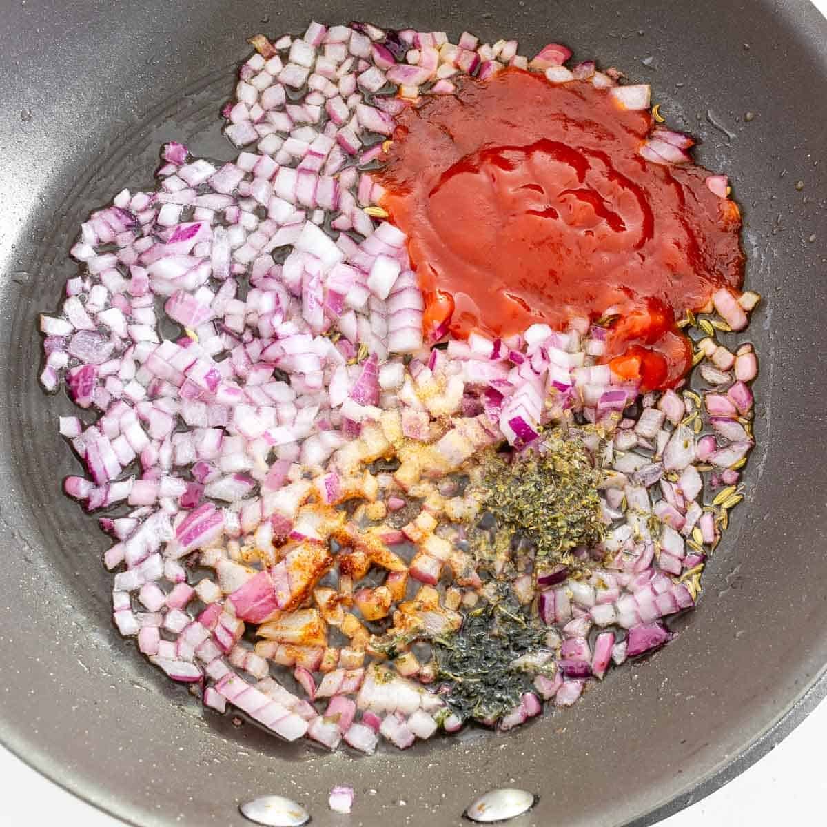 all the seasonings and herbs in the nonstick pan with onions.