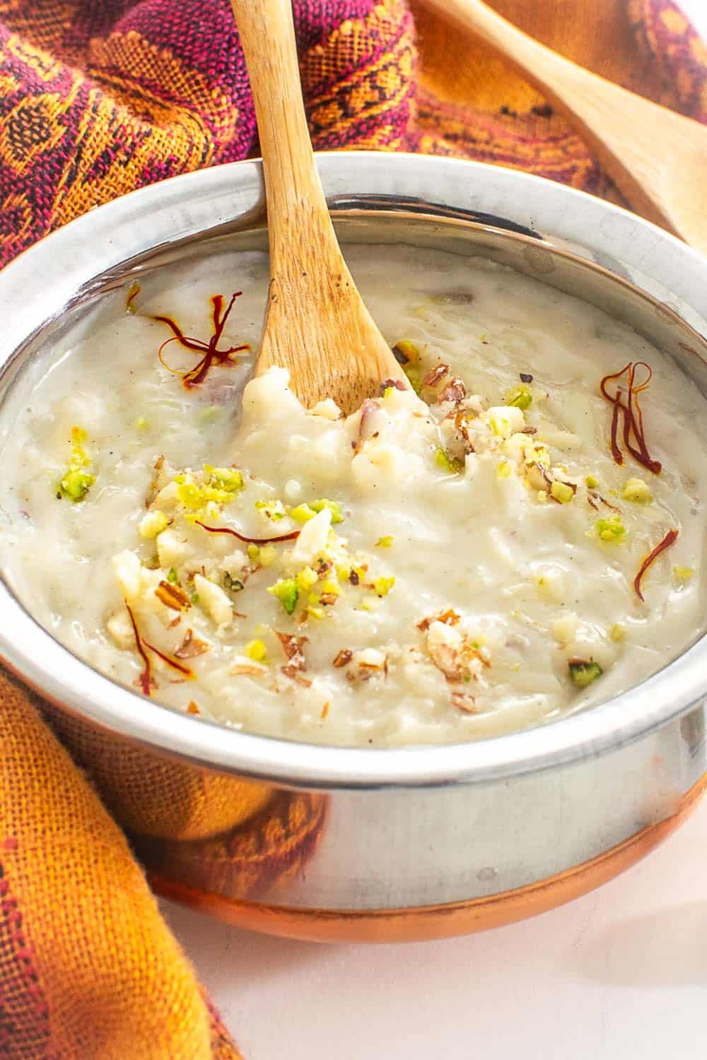 a spoon digging into the bowl of rice pudding.