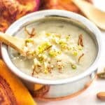 a spoon scooping Indian rice pudding from the bowl.