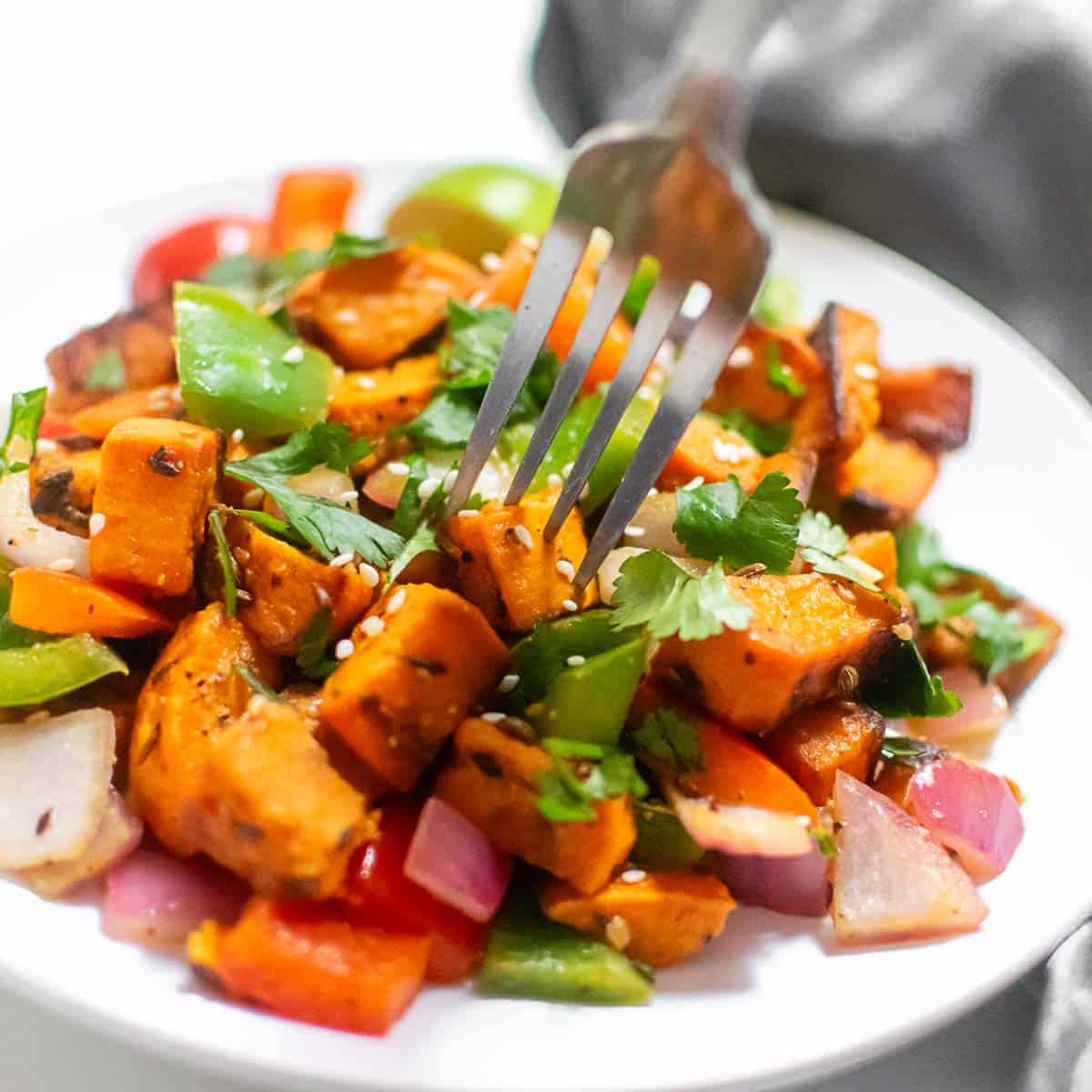 a fork digging into the vegetables in the serving plate.