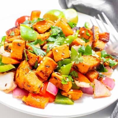 a 45 degree angle view of sweet potato stir fry in a serving plate.