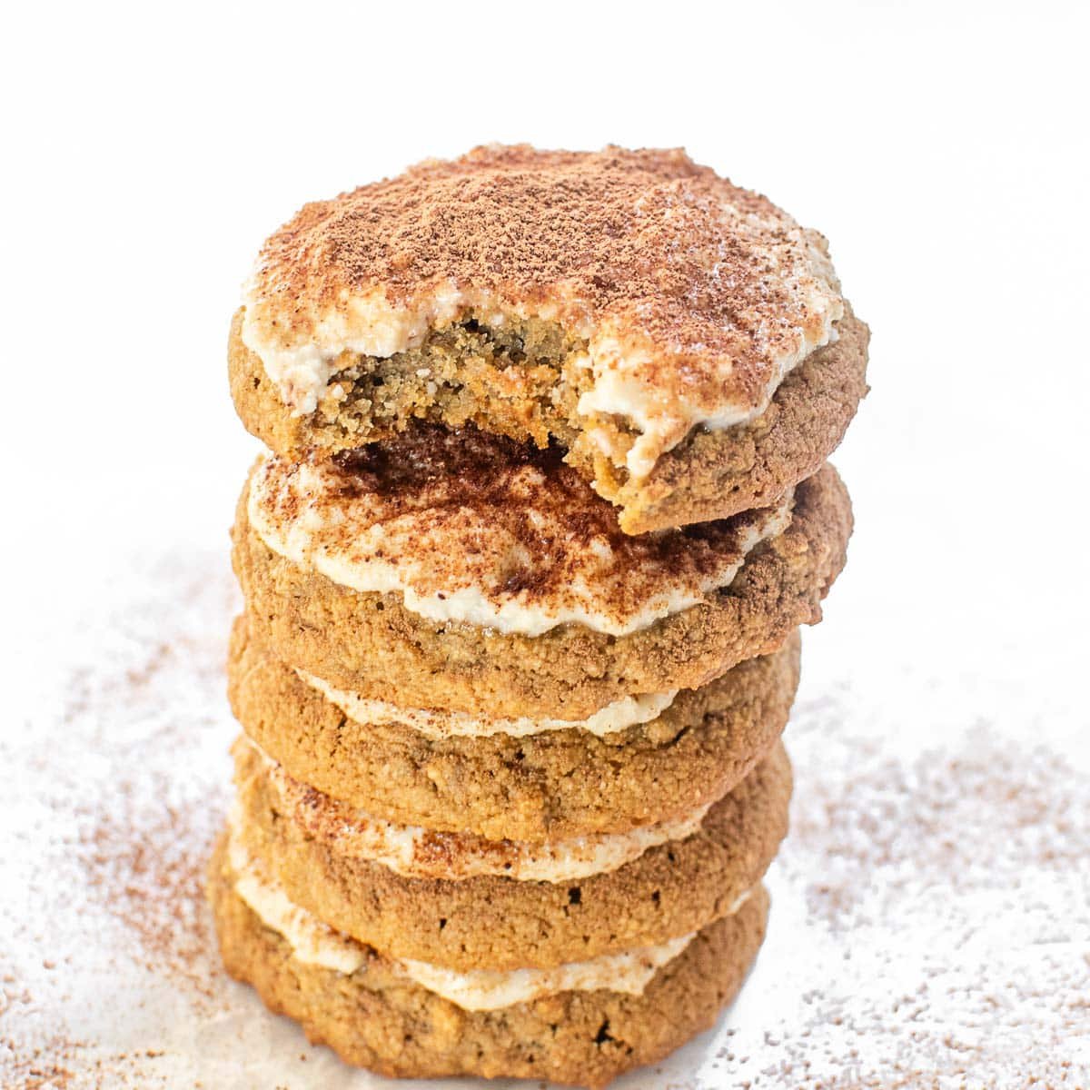 half eaten cookie on a tall stack of tiramisu cookies.