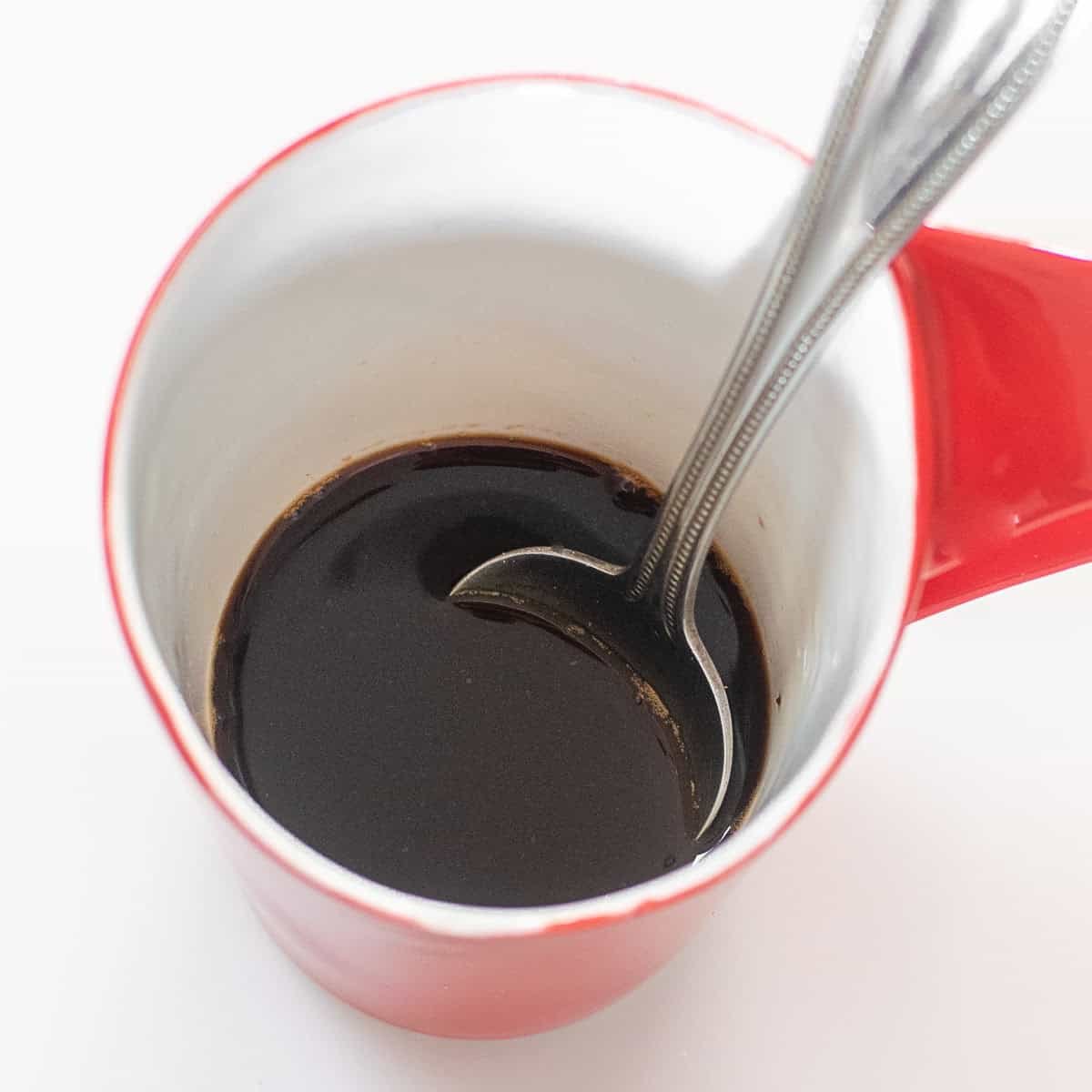 brewed coffee in a cup with a spoon.