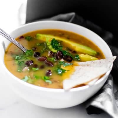 a spoon scooping black bean soup from the bowl.