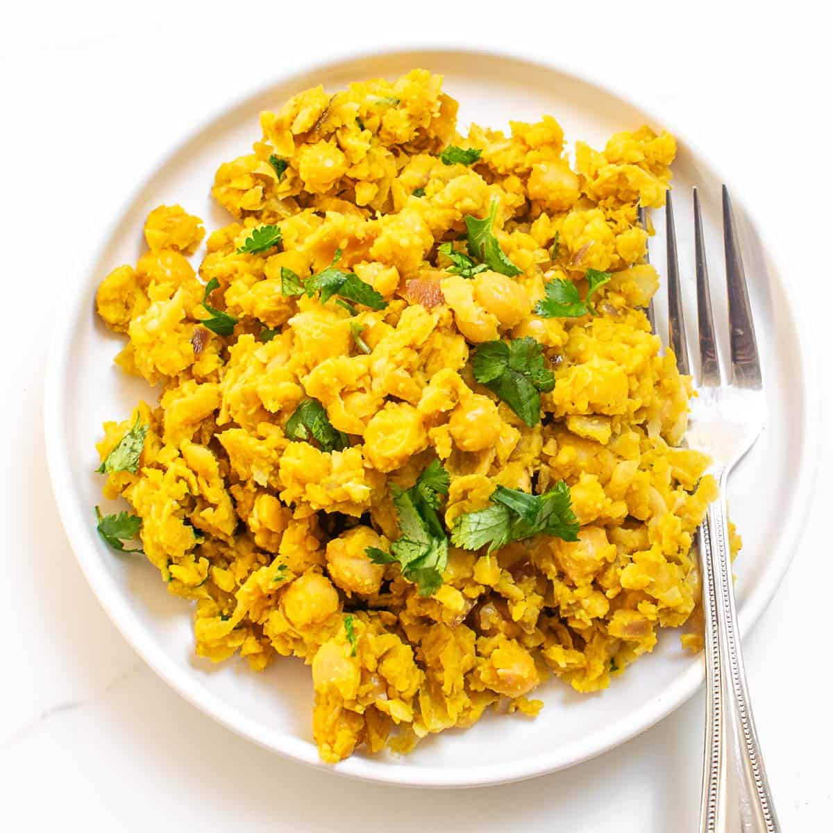 top view of chickpea scramble with garnishes in a serving plate. 