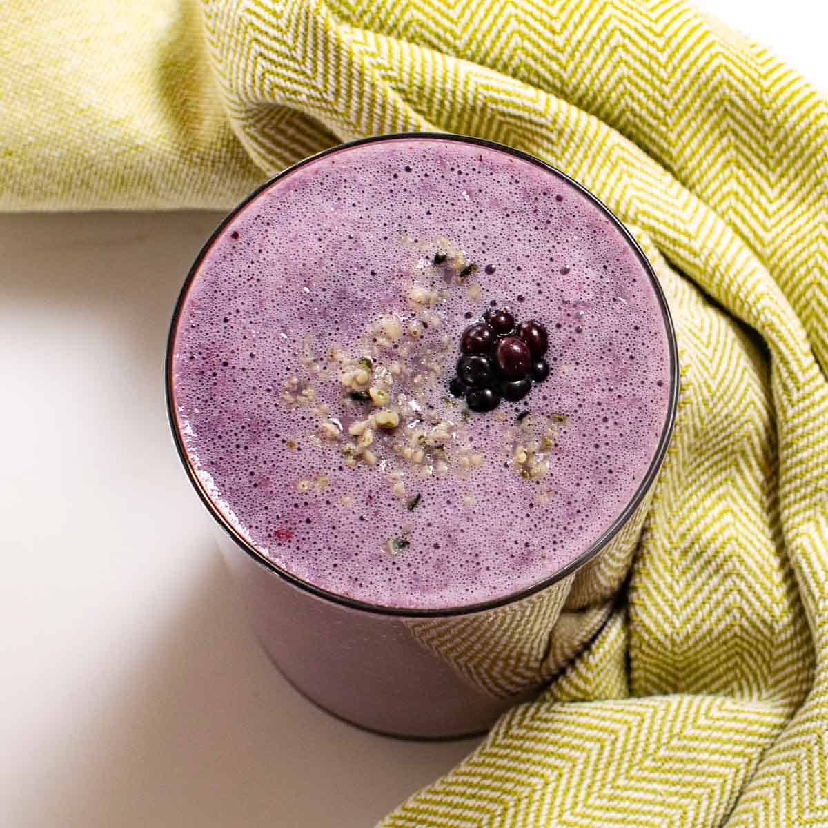 top close up view of served blackberry smoothie with garnishes.
