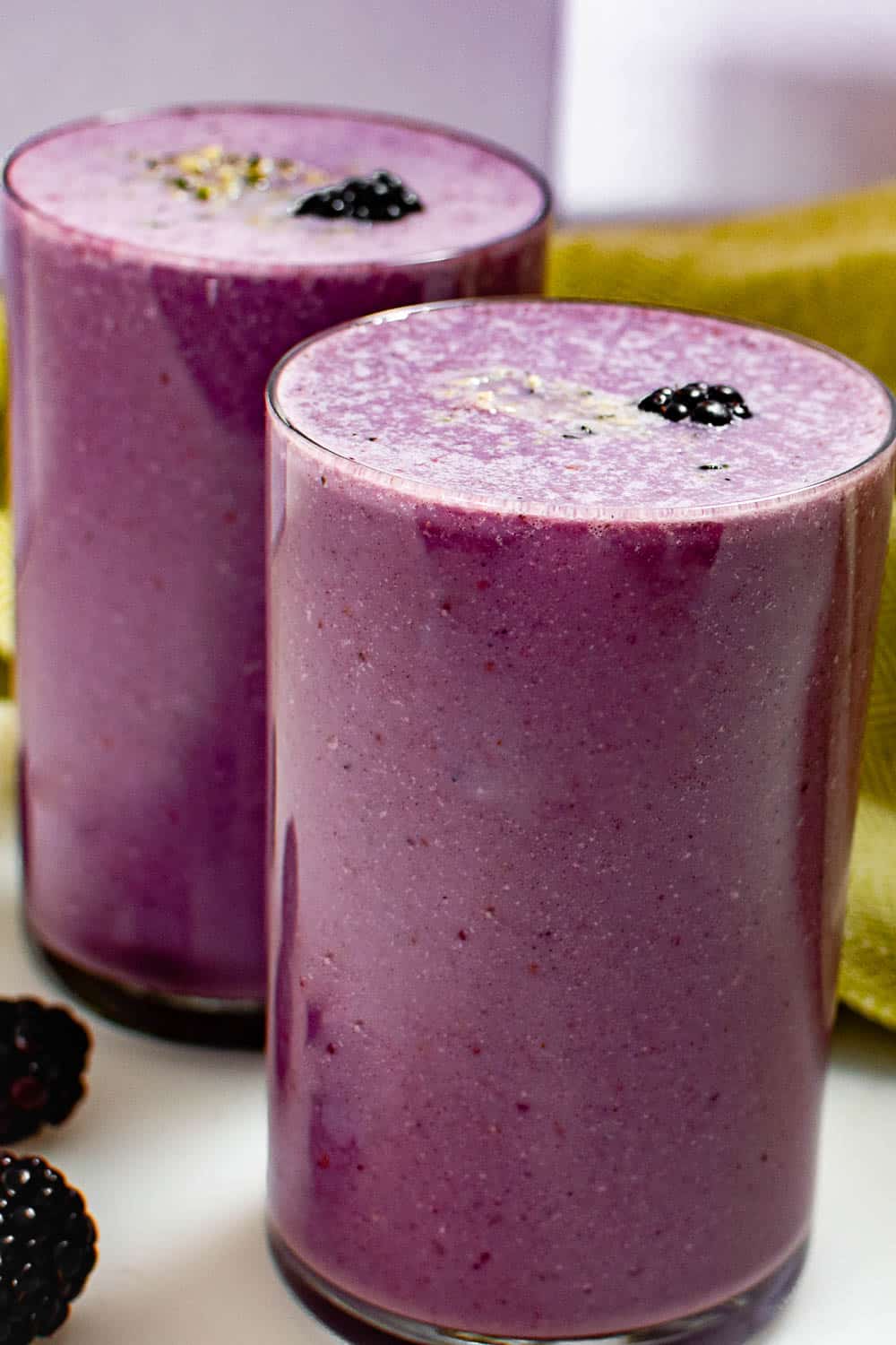 tall glasses filled with blackberry smoothie and served.