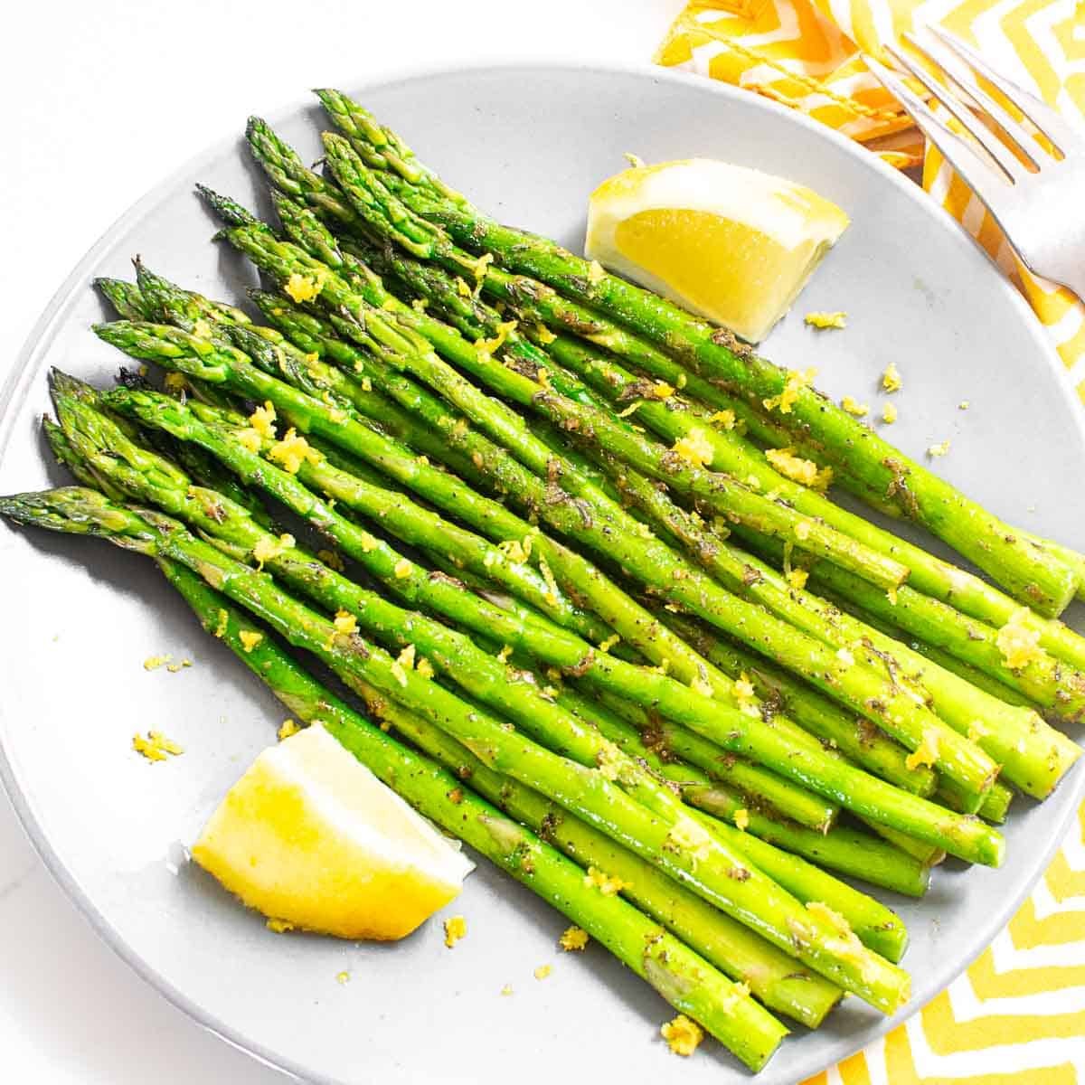 top view of served pan fried asparagus with its garnishes.