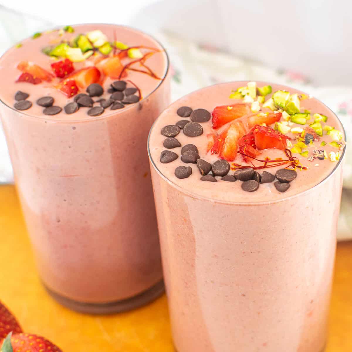 a 45 degree angle view of served strawberry lassi.