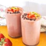 two tall glasses filled with strawberry lassi.