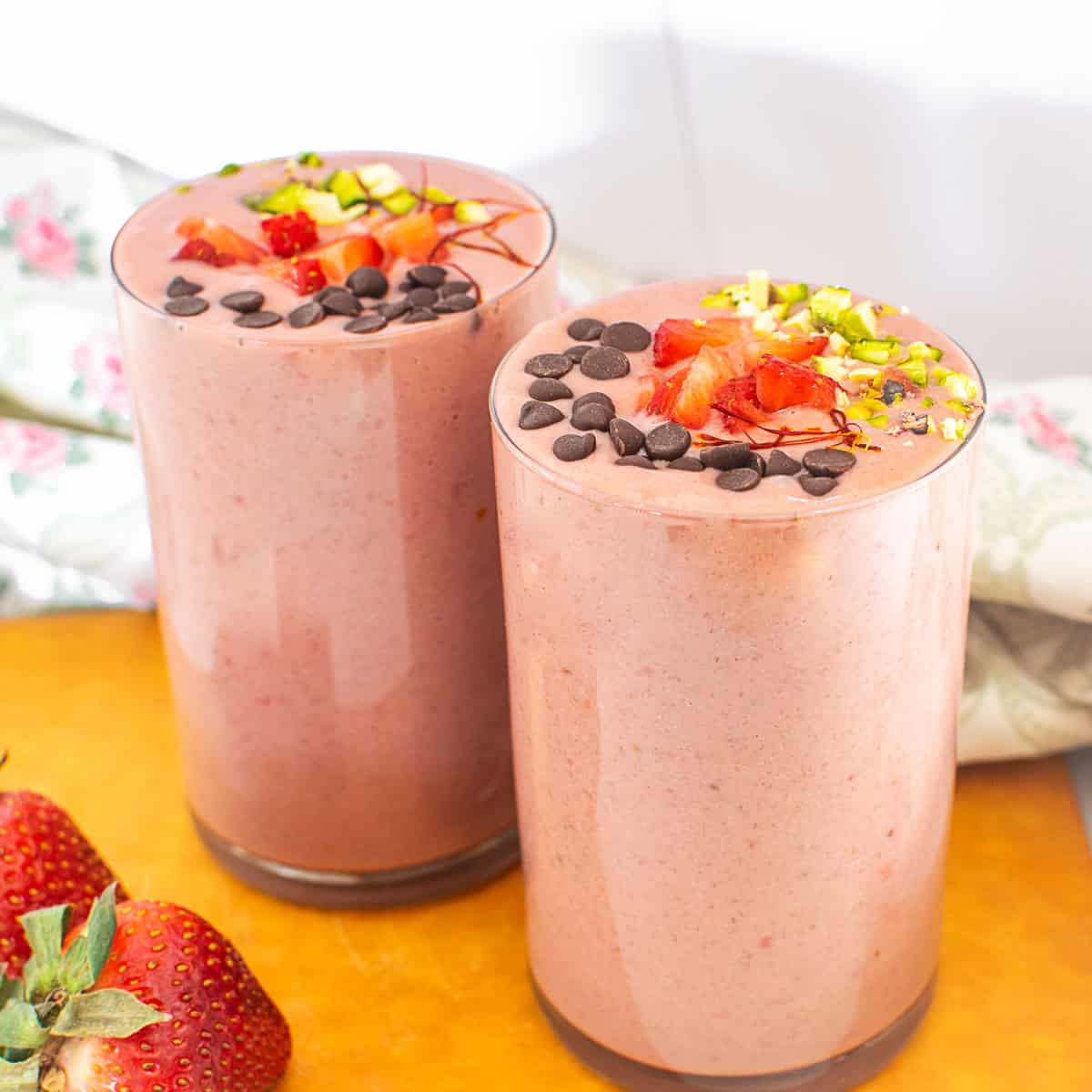 two tall glasses filled with strawberry lassi.