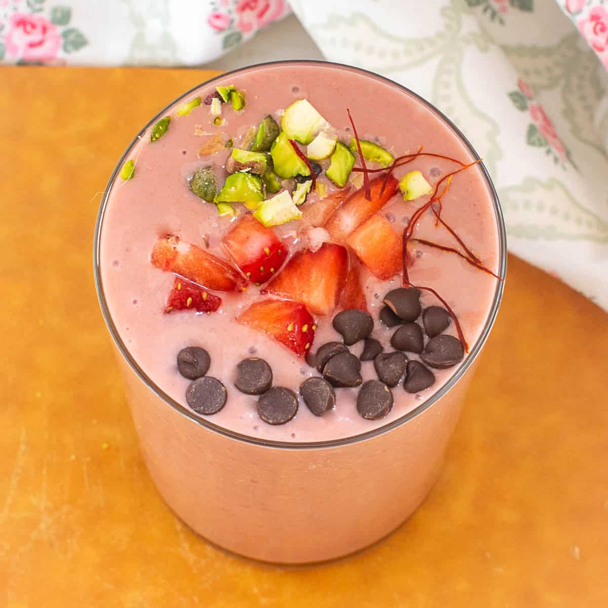 top view of garnished strawberry lassi in a serving glass.