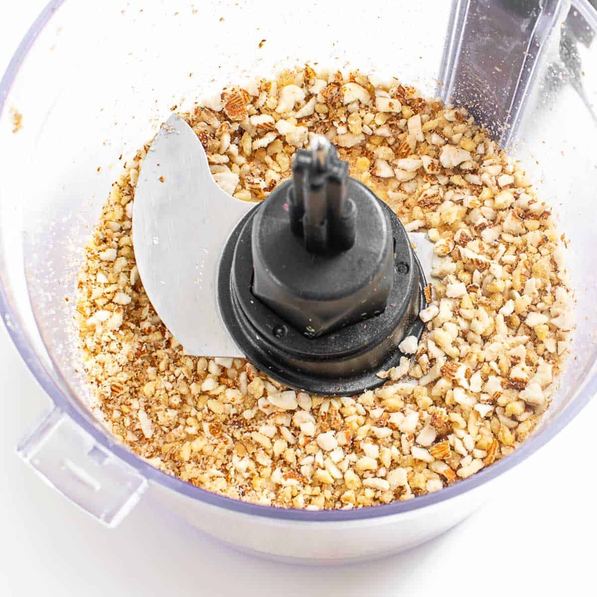 Preparing the nuts by crushing them in the food processor to make the mixture.